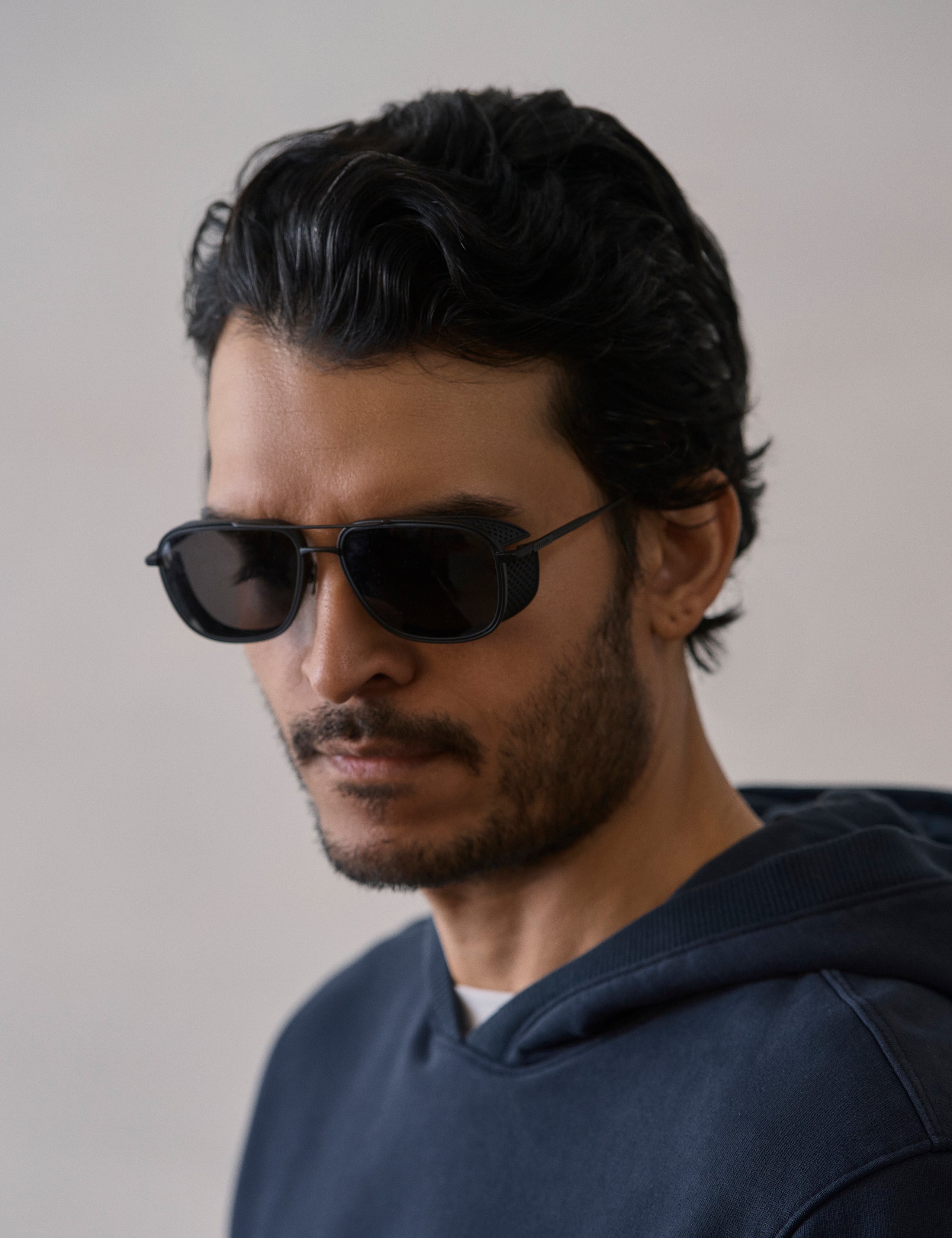Front 3/4 view of man wearing Summit Sunglass in Black titanium with black lens from AETHER Apparel.