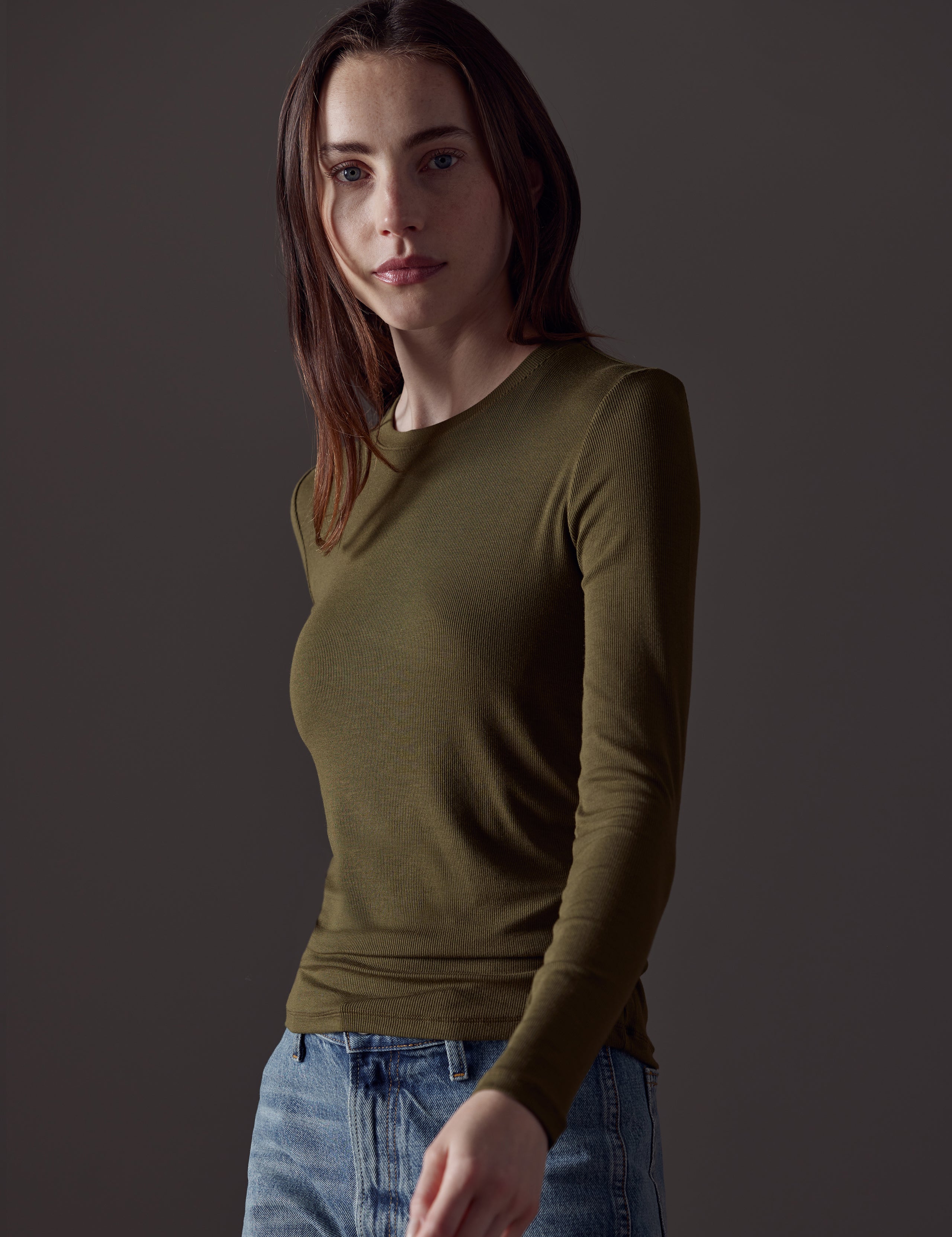 Front angled view of woman wearing Legacy Long-Sleeve Crew in Command Green from AETHER Apparel.