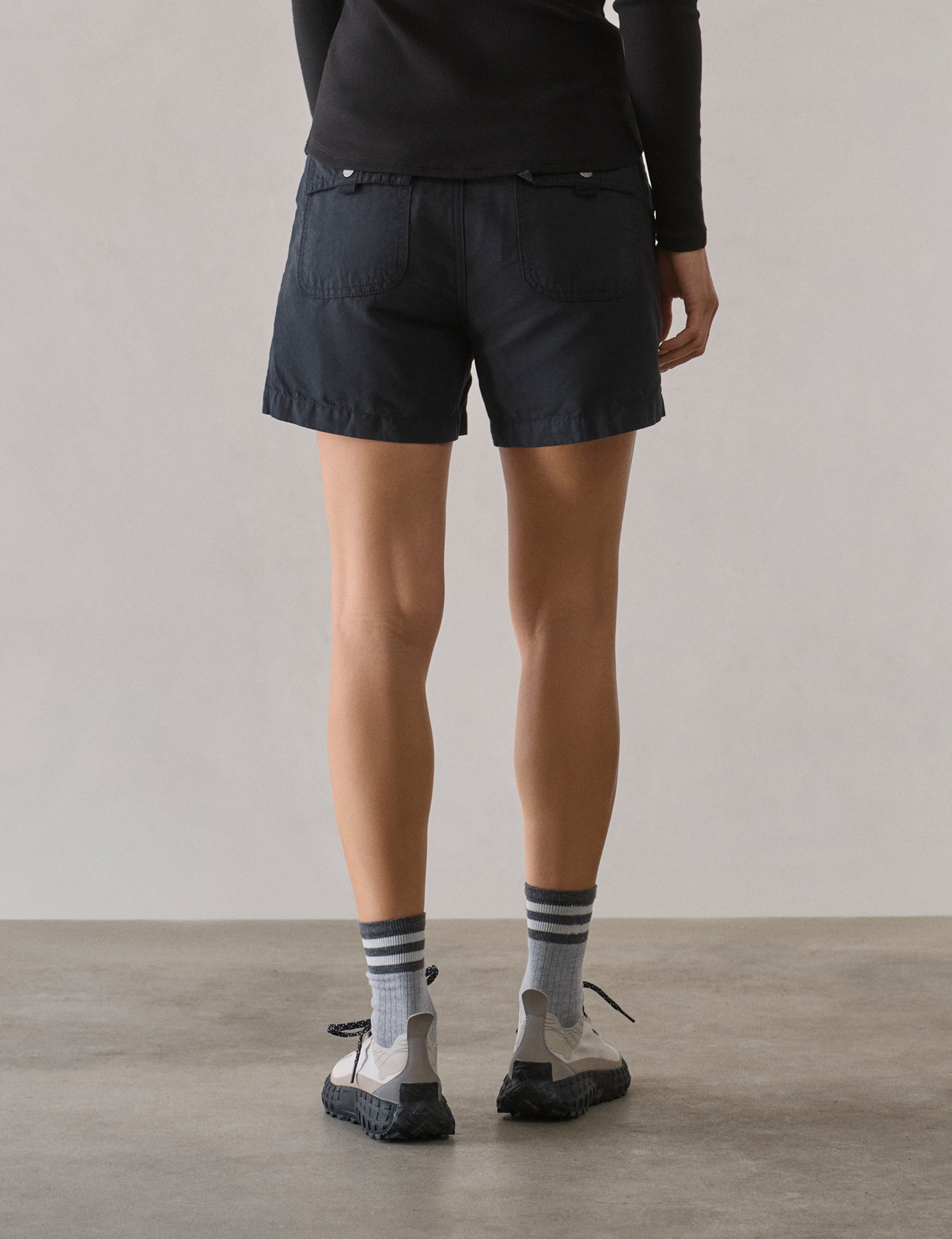 Rear lower body view of woman wearing Masai Safari Short in Onyx Black from AETHER Apparel.